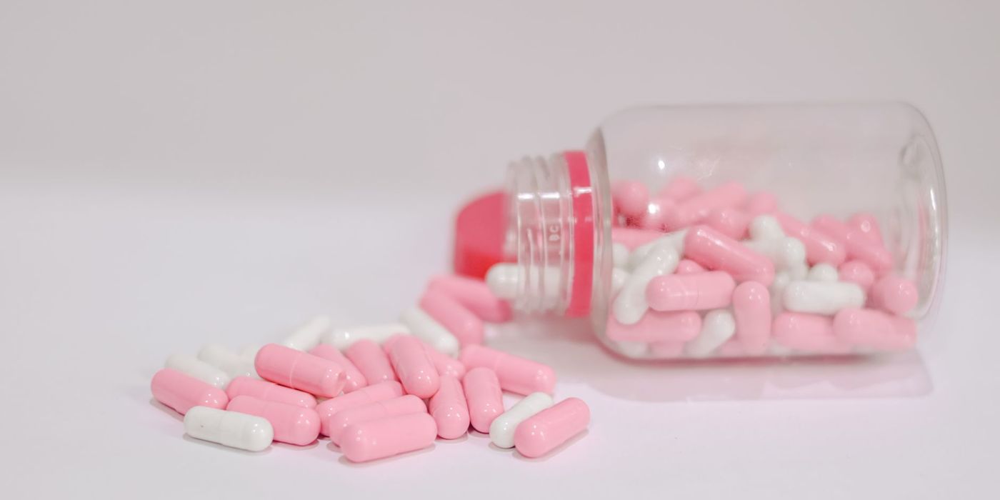 Pharmaceutical capsules spilling from a bottle