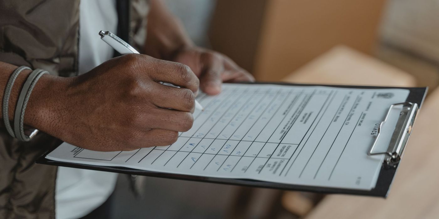 Filling in a requirements checklist on a clipboard