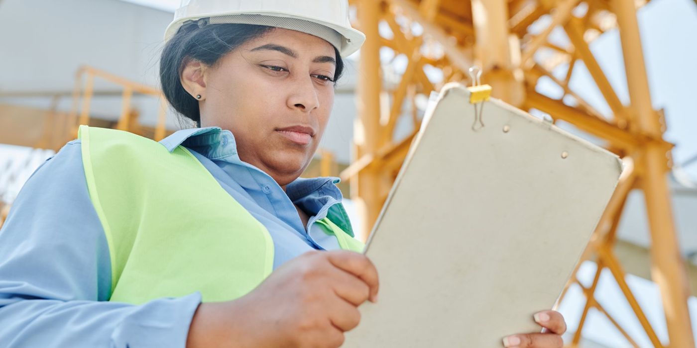 An auditor reviewing findings on a clipboard at a facility
