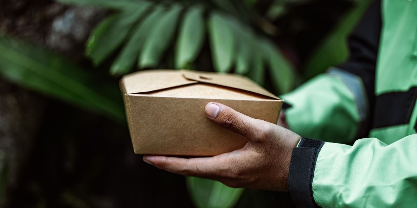 A rider holding a halal food takeaway box